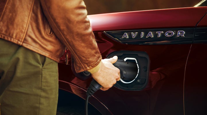 A hand is shown plugging in the charger into the charging port of a 2021 Lincoln Aviator | Gary Yeomans Lincoln Ocala in Ocala FL