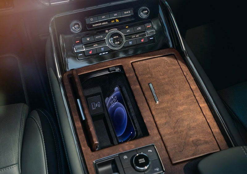 A smartphone is charging on the wireless charging pad* in the front center console cubby. | Gary Yeomans Lincoln Ocala in Ocala FL