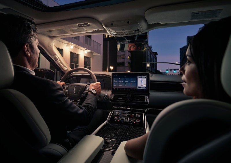 A couple is relaxing inside their quiet and serene 2023 Lincoln Navigator SUV. | Gary Yeomans Lincoln Ocala in Ocala FL