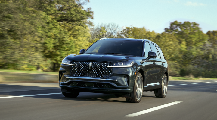 A 2025 Lincoln Black Label Aviator® SUV is being driven down a road lined with trees. | Gary Yeomans Lincoln Ocala in Ocala FL