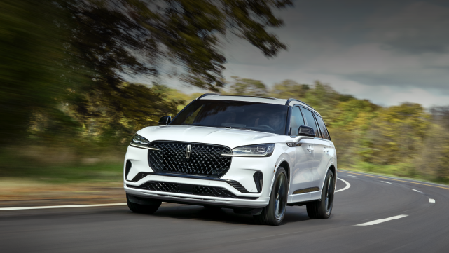 A white 2025 Lincoln Aviator® SUV is being driven down a road lined with trees. | Gary Yeomans Lincoln Ocala in Ocala FL